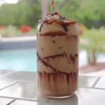 Side view of a peanut butter iced coffee on a tile counter.