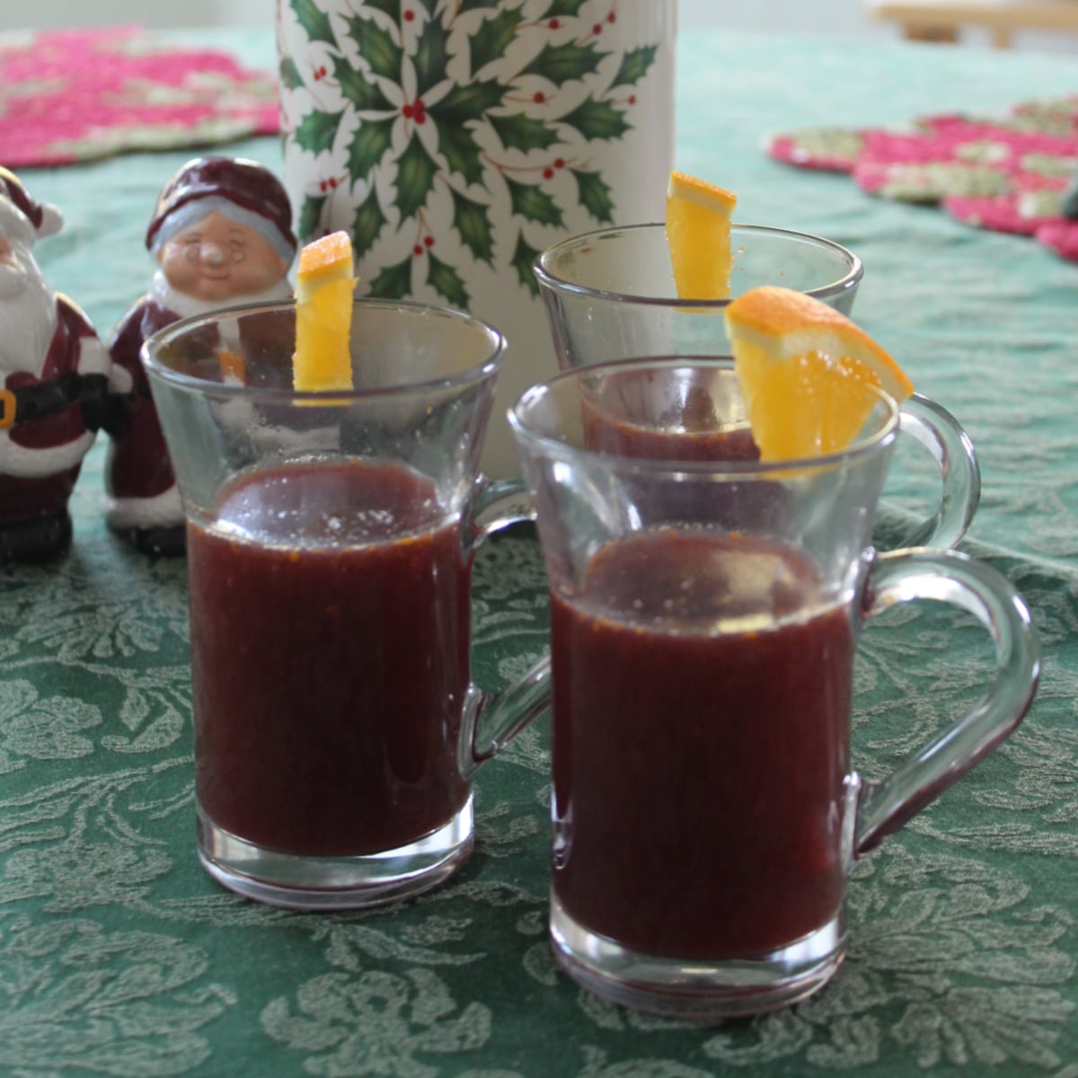 Three mugs of crockpot mulled wine on a table.