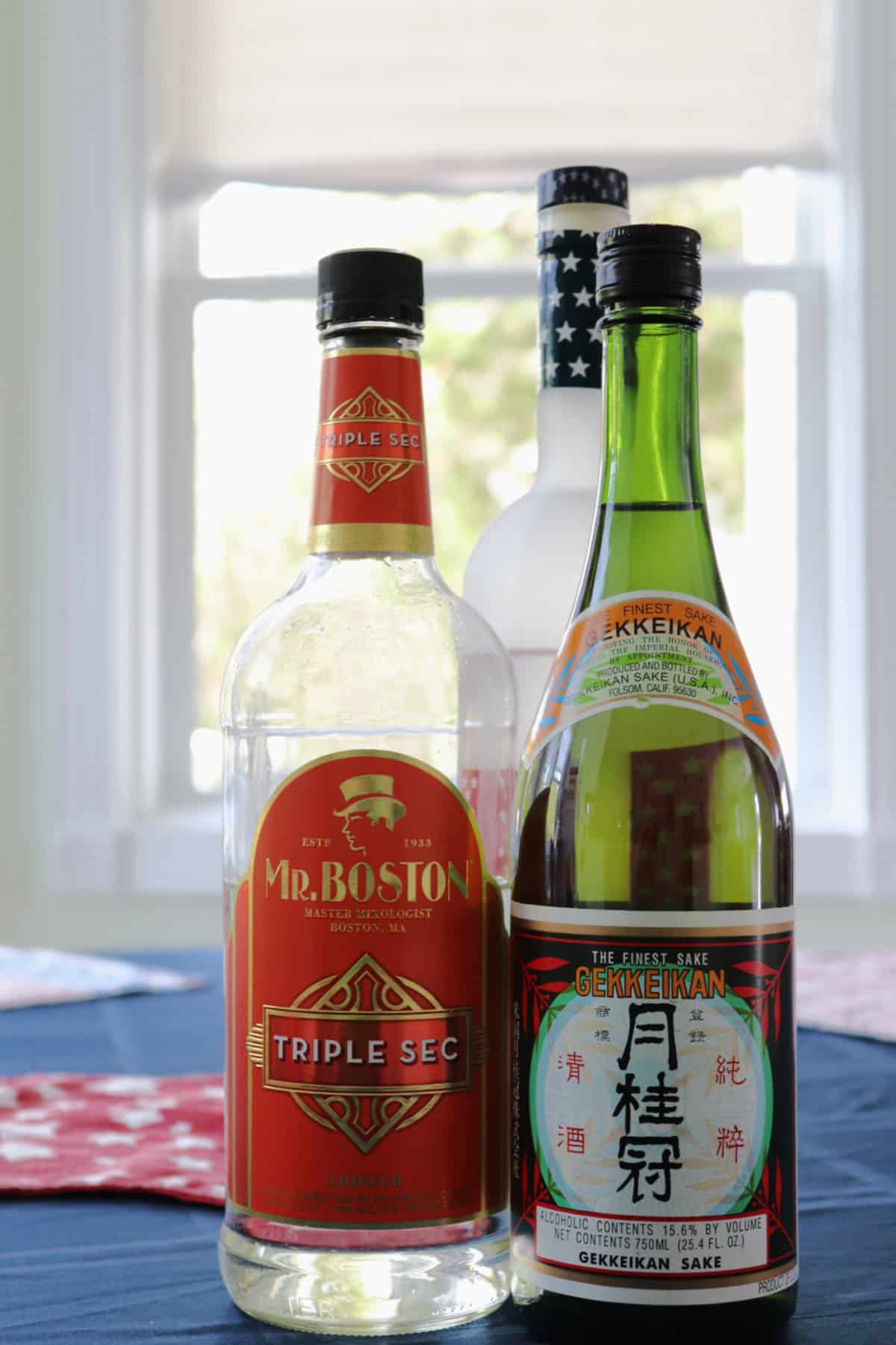 Saketini ingredients - 3 bottles on a table.