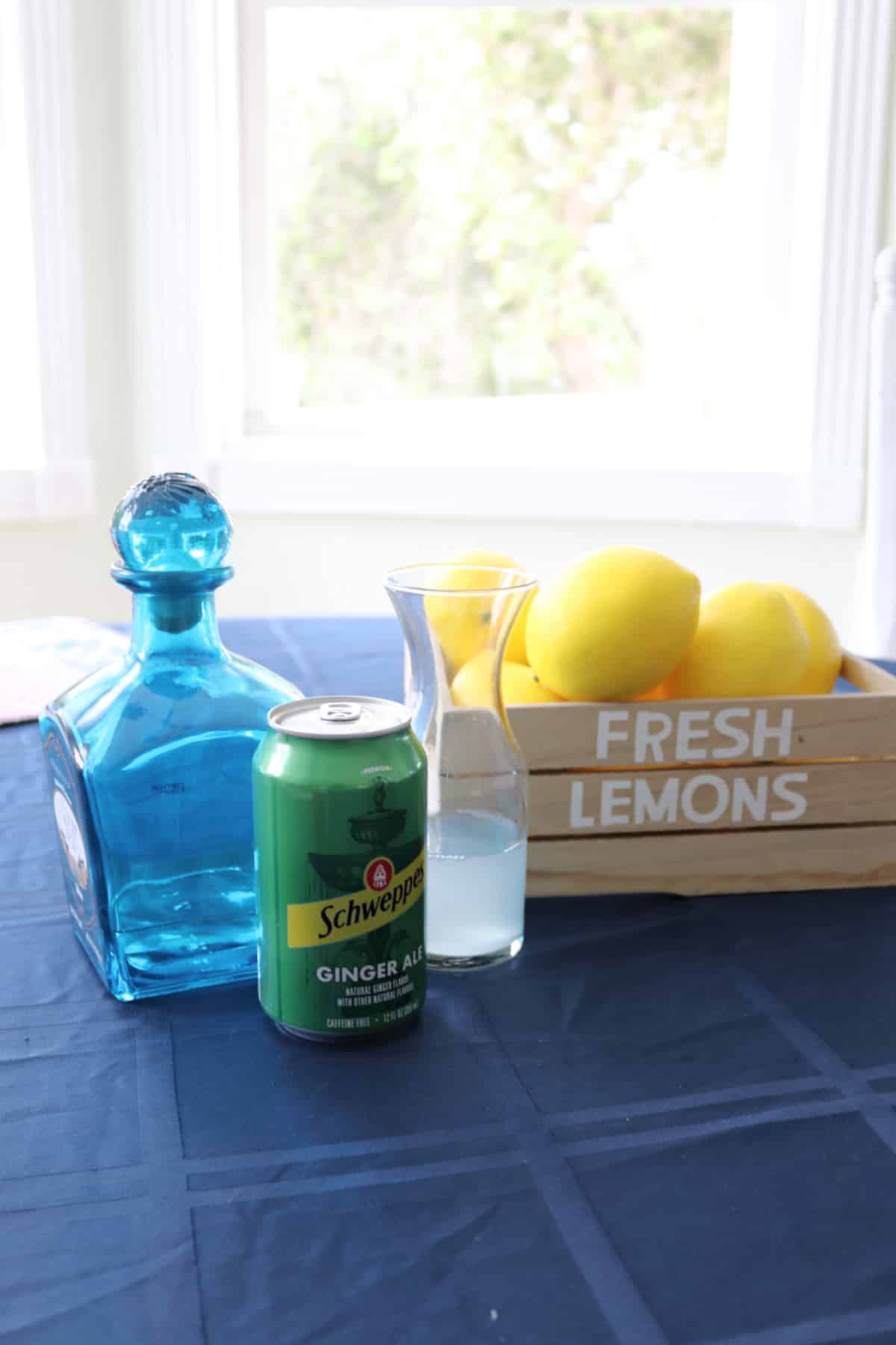 Lemonade Tequila Cocktail ingredients on a blue tablecloth.